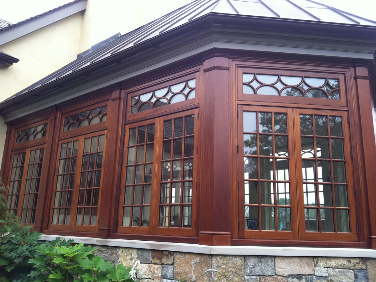 A mahogany conservatory bay with decorative arched glazing patterns
