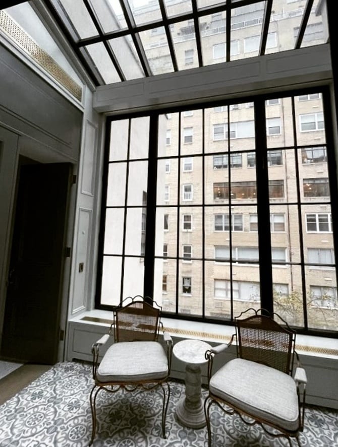 A steel-framed skylight and window wall overlooking a New York apartment building
